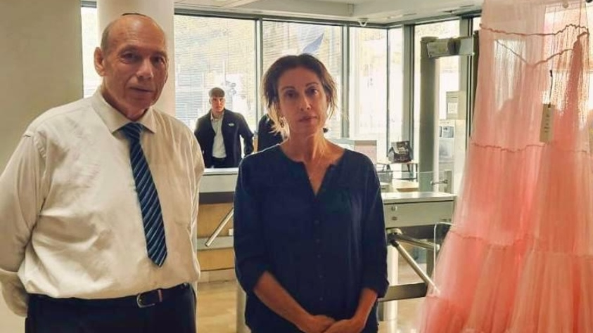 המבקר אנגלמן עם אוצרת התערוכה, קרן גולדשטיין והשמלה של ענת אלימלך ז"ל